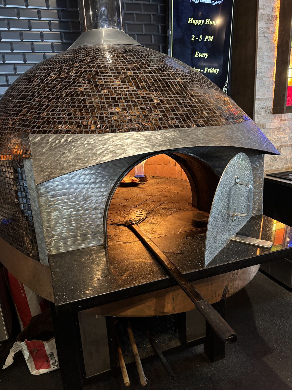The wood-fired brick oven at Maple Street Tavern in Wyandotte, fire lit inside the dome