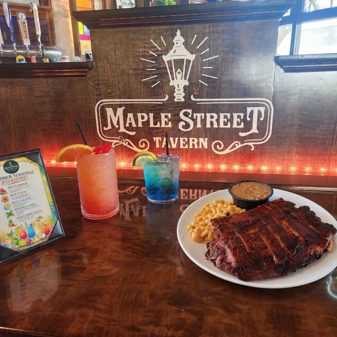 Dry-rubbed ribs with mac and cheese, baked beans and two cocktails under the tavern sign